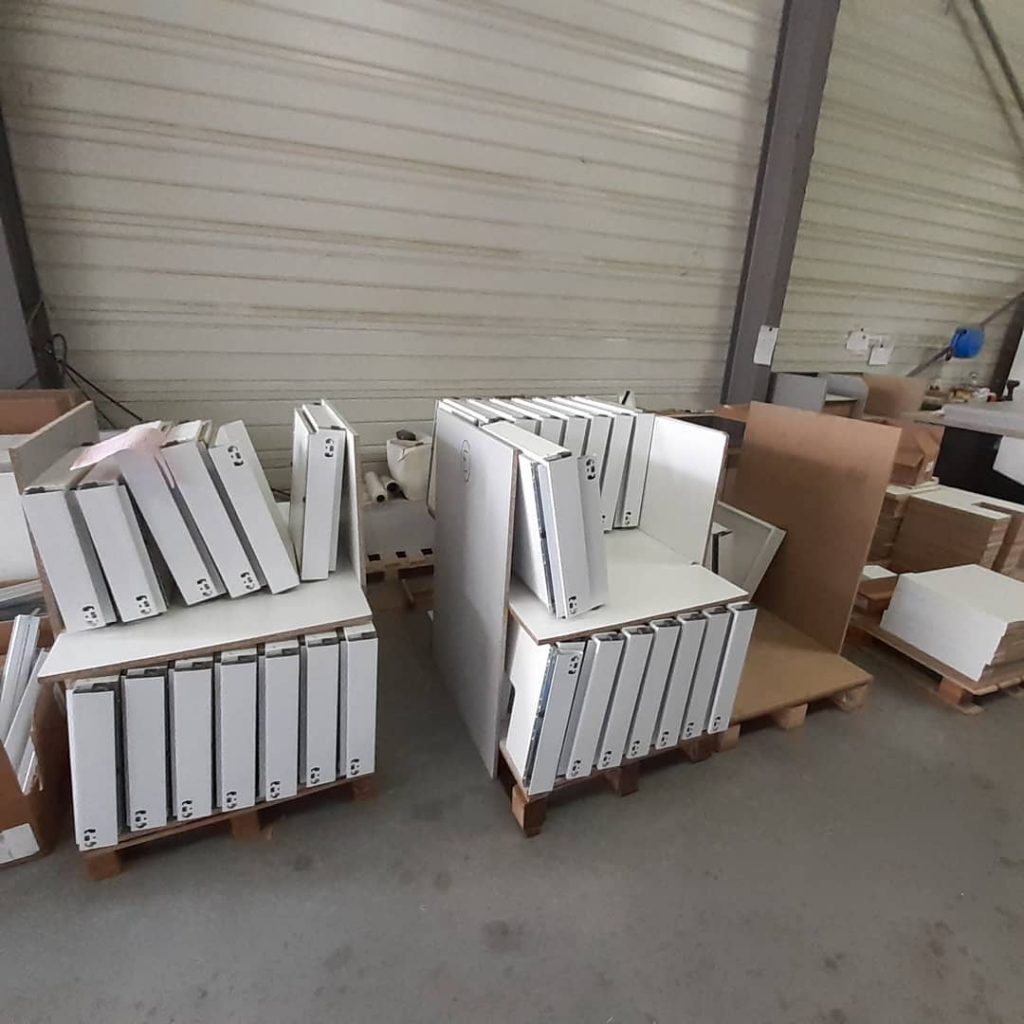 Montage et préparation sur palettes de tiroirs de meubles de cuisine.