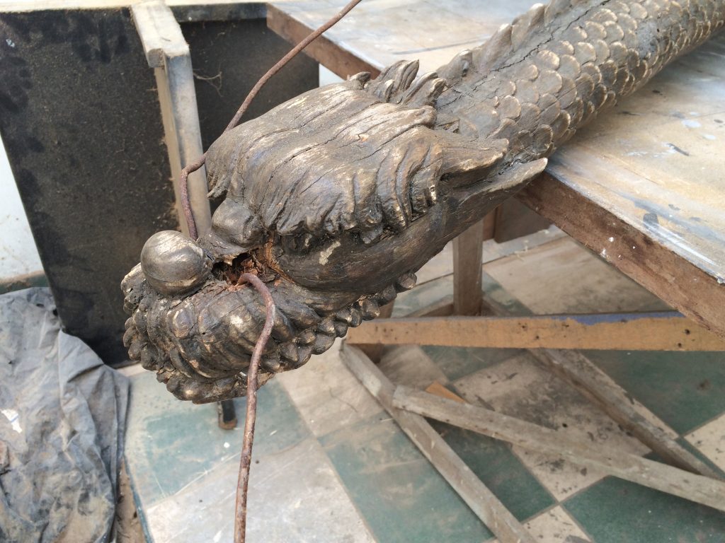 Restauration d'un dragon en bois.